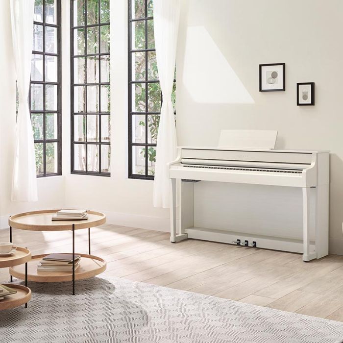 Yamaha baltas digitālās klavieres viesistabā pie sienas
